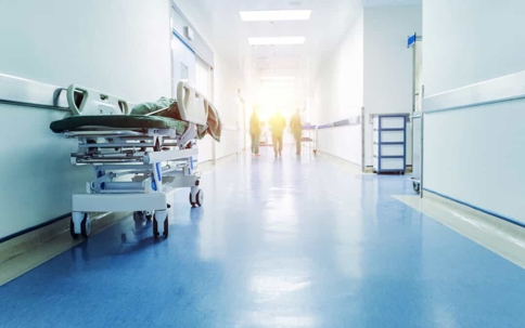 Hallway of a hospital with a gurney and doctors